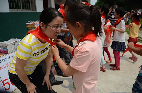 捐贈(zèng)儀式上，孩子們?yōu)閻?ài)心天使系上紅領(lǐng)巾