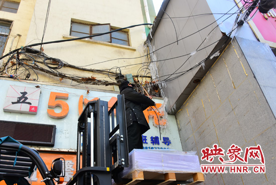 站在叉車(chē)升高的叉板上除冰