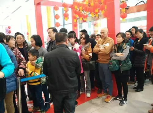 排隊(duì)領(lǐng)年貨，一家老小齊上陣。