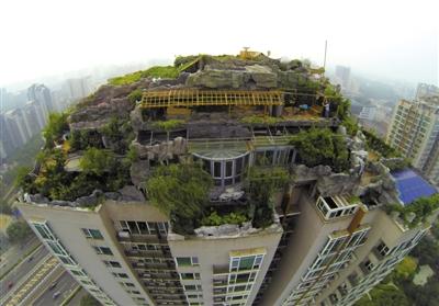 　　昨日，身穿橘黃色馬甲的工作人員在人濟(jì)山莊樓頂拆除違章建筑。新京報(bào)記者 吳江 攝