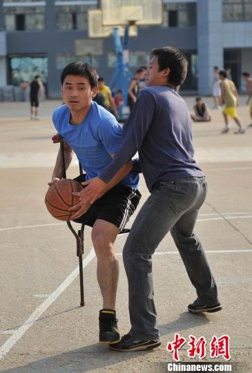 圖為拄著拐杖的瞿詩濤和同學(xué)搶球。劉占昆攝