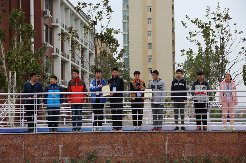 副校長賈軍杰（左一）為創(chuàng)新機(jī)器人社團(tuán)的學(xué)生頒發(fā)證書