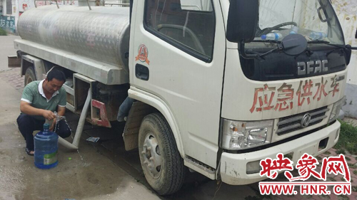 柘城縣黃山小區(qū)的居民，因為停水，只能接了自來水再往樓上搬。
