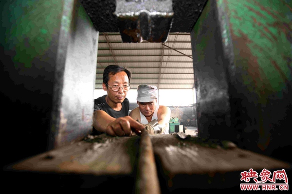 劉金玉正與工友一起用自己發(fā)明的綜合液壓機(jī)對廢舊錨桿進(jìn)行軋直處理