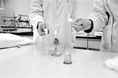 實驗人員操作的燃燒檢測法中，真蠶絲離開火焰就熄滅(左)。