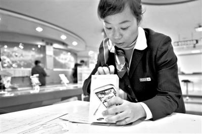 11月6日，北京移動西直門營業(yè)廳的工作人員在為顧客購買的4G手機登記。新華社發(fā)