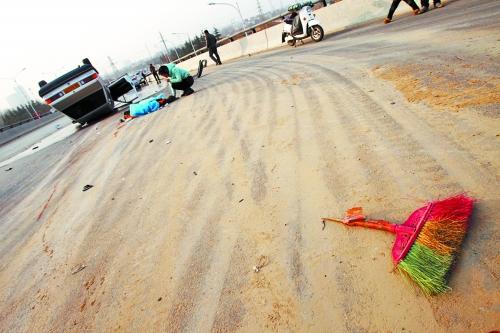 被撞的環(huán)衛(wèi)工躺在地上，身上蓋著藍色布塊，現(xiàn)場除散落的汽車碎片外，還留有被撞斷的掃帚。