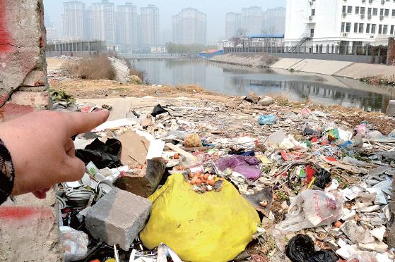 金水河長(zhǎng)江路橋下河水發(fā)臭，水邊堆放眾多垃圾