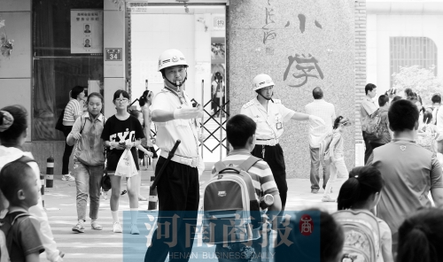 伊河路小學門口，兩名巡防隊員護送學生過馬路