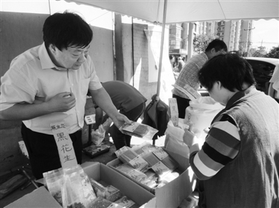 昨日，河南企業(yè)家劉春喜在京“練攤”，為顧客挑選綠豆。新京報記者 張玉學(xué) 攝