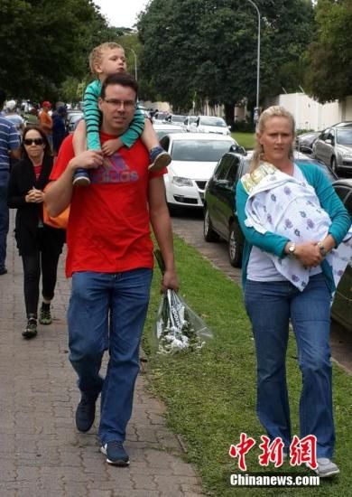 圖為一個白人家庭，由父母帶著孩子到曼德拉家門外悼念。中新社發(fā) 宋方燦 攝