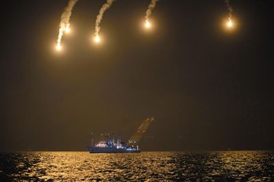 22日，搜救人員在照明彈的光亮下連夜搜救。