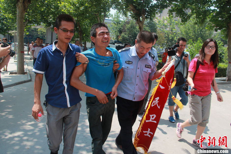 圖為獲救嬰兒父親情緒一度失控，當(dāng)?shù)鼐焦ぷ魅藛T對其進(jìn)行攙扶。張一辰 攝