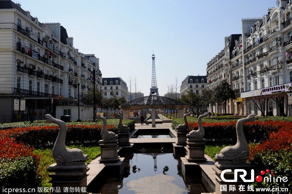 　2014年3月21日，杭州天都城，農(nóng)民在山寨埃菲爾鐵塔下耕作。圖片來源：東方IC