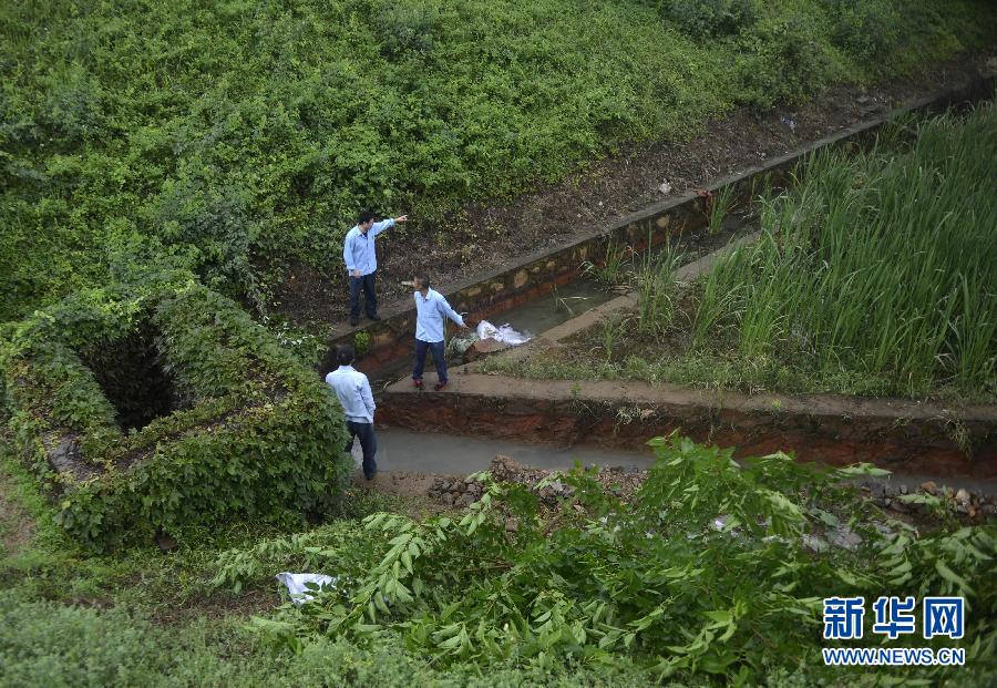 5月18日，工作人員在槽罐車泄漏現(xiàn)場(chǎng)附近的水渠邊查看情況。