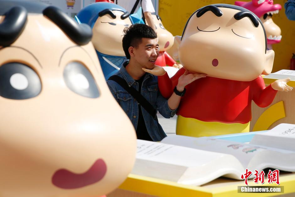 4月22日，游客與蠟筆小新合影?！跋灩P小新25周年紀(jì)念特展”日前在北京開展，吸引了不少市民游客。