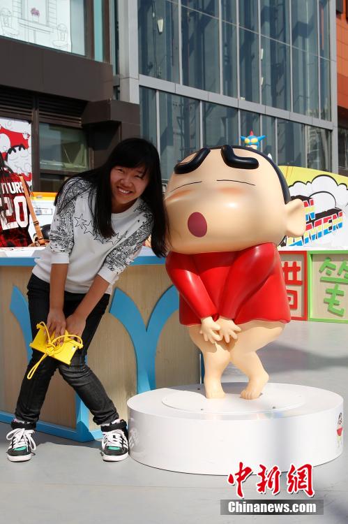 4月22日，游客與蠟筆小新合影?！跋灩P小新25周年紀(jì)念特展”日前在北京開展，吸引了不少市民游客。