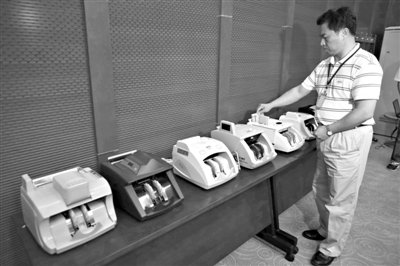 昨日，央行工作人員用各種驗鈔機對C1F9假幣進行測試，機器均能及時作出異常報警反應。新京報記者 浦