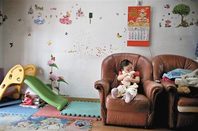 6月14日，未婚媽媽于軍的家里。女兒悅悅抱著兔子玩偶，在聽媽媽手機上的兒歌，這個4歲女孩喜歡兔子。