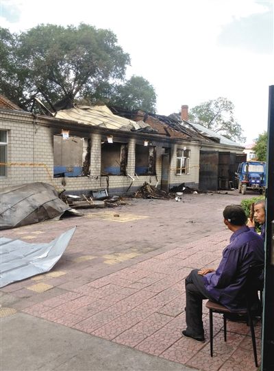 7月27日，海倫聯(lián)合敬老院內(nèi)，幾名老人看著對面被燒毀的特護(hù)病房。新京報記者 涂重航 攝