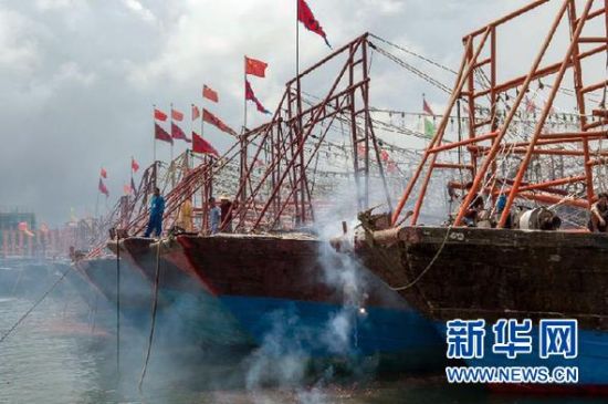 2013年8月1日 南海開漁日 臨高迎新港 8月1日，海南省臨高縣漁民在船上鳴放鞭炮慶祝武蓮港開港。