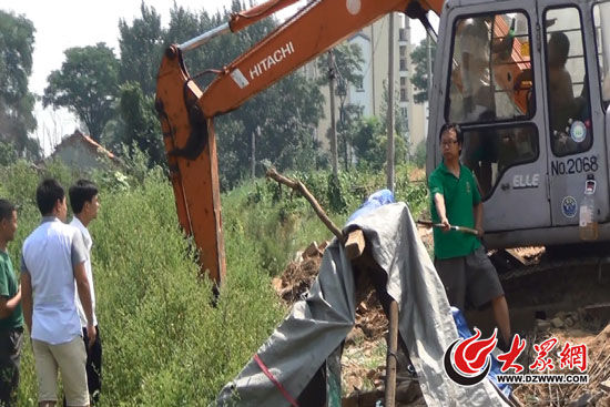 陳寶成手持自制刀斧守在挖掘機(jī)旁阻止便衣民警靠前。駕駛室內(nèi)，張朋珂正向受害人郭曉剛身上澆汽油。（視頻截圖）