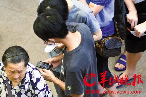 排隊(duì)的“黃?！备魇謭?zhí)一疊白紙，上面寫好了要掛號(hào)的人的信息，包括姓名、電話、要掛的科室等。穿黑白花紋衣服的老婆婆正在排隊(duì)掛號(hào)