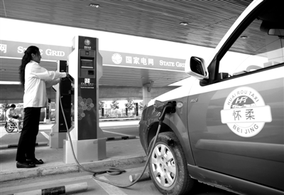 9月11日，懷柔區(qū)，電動(dòng)出租車司機(jī)正在為車輛充電。