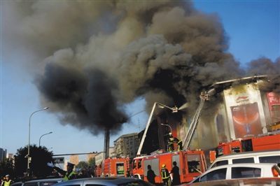 11日，蘋果園喜隆多商場(chǎng)，火災(zāi)現(xiàn)場(chǎng)濃煙滾滾。新華社發(fā)