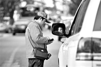 10月15日，朝陽區(qū)東大橋路，停車管理員從腰間掏出一個(gè)專用POS機(jī)，正在錄入停車信息。新京報(bào)記者 周崗峰 攝
