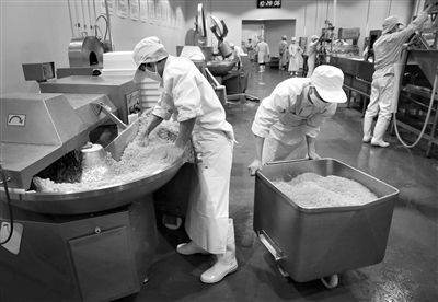 昨日，位于順義李遂開發(fā)區(qū)的慶豐包子鋪配送中心生產(chǎn)車間，工人們正在斬拌胡蘿卜餡料。