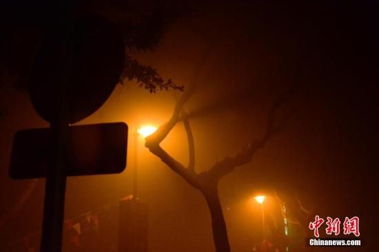 1月31日凌晨，市民行走在煙霧繚繞的南京街頭。當(dāng)天是農(nóng)歷馬年正月初一，南京有限開禁燃放煙花爆竹正逢下霧天，空氣的不流通致使煙花爆竹燃燒后產(chǎn)生的顆粒物不能及時(shí)散開，造成整座城市煙霧繚繞。據(jù)當(dāng)?shù)丨h(huán)保部門發(fā)布的信息顯示，空氣質(zhì)量屬重度污染。中新社發(fā) 泱波 攝