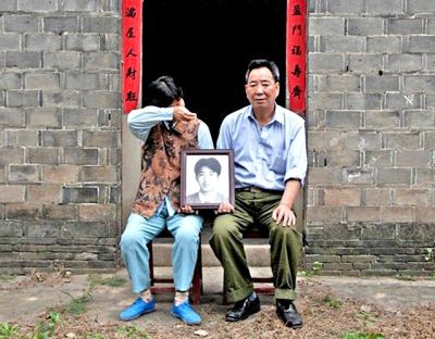 江蘇鎮(zhèn)江，老劉夫婦捧著獨(dú)生子的遺像在老家前留影南方都市報(bào)供圖L