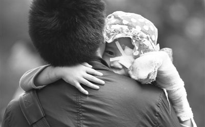 昨日，北京同仁醫(yī)院，被砍傷的彤彤趴在舅舅的肩上。他們剛剛掛完號(hào)，正準(zhǔn)備回旅館。新京報(bào)記者 尹亞飛 攝