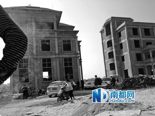 兩棟被舉報(bào)的違建樓下昨日一度聚集了超過(guò)百人，城管離開后逐漸散去。南都記者張志韜實(shí)習(xí)生宋超攝