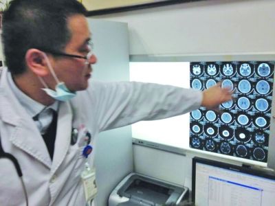 醫(yī)生在查看男孩的腦部CT片。薛馬義 攝