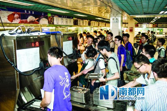 昨日，華南理工大學(xué)一食堂內(nèi)，學(xué)生們正在使用新安裝的自動打飯機打飯。中新社發(fā)