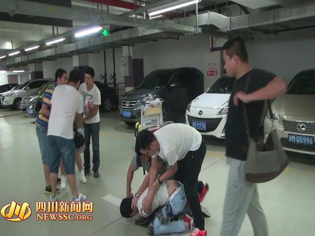 辦案人員在機(jī)場(chǎng)停車(chē)場(chǎng)抓獲胡某及其女友（警方視頻截圖）。