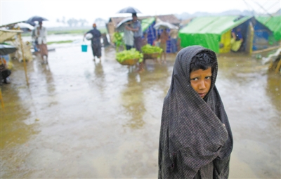 5月14日，緬甸若開邦實兌難民營，羅興亞族難民在雨中行走。熱帶風(fēng)暴“馬哈森”即將登陸緬甸，這里的難民開始乘船撤離。