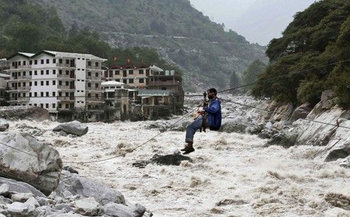 一名印度男子靠繩索渡河。