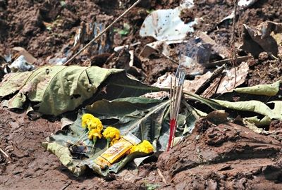 失事現(xiàn)場(chǎng),有人擺上鮮花放上香燭表示悼念。