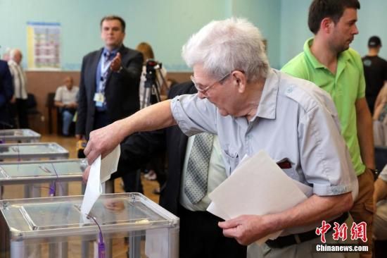 　5月25日，一名烏克蘭選民把填好的選票投入選票箱。