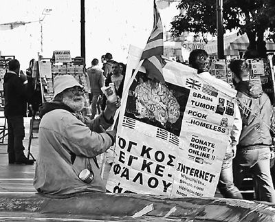 自債務危機爆發(fā)以來，希臘承諾實施以減薪、增稅、裁員和私有化為主要內(nèi)容的緊縮和改革政策。一系列的緊縮措施使民眾生活受到嚴重影響，約1/4的家庭陷入貧困。圖為今年1月希臘大選期間，在雅典市中心國會大廈前廣場乞討的老人。