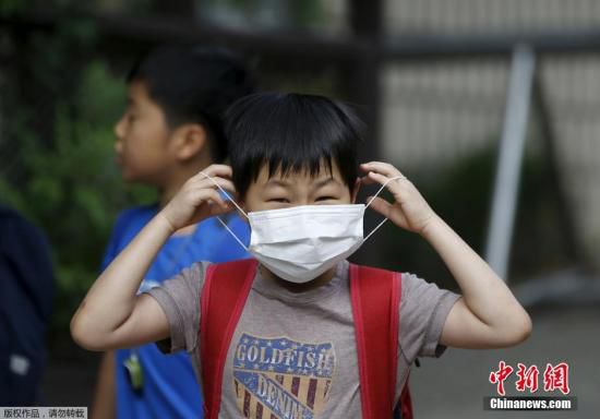 圖為當(dāng)?shù)貢r(shí)間2015年6月8日，韓國(guó)未停課的學(xué)校，學(xué)生課前戴口罩測(cè)體溫。