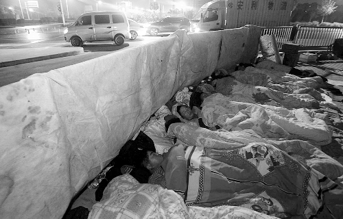 在寒冷的冬夜，為了能省點錢，方便接活，民工們仍睡在橋下。