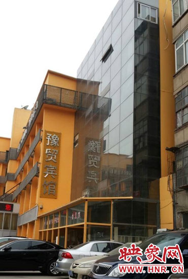 該酒店為加蓋樓層統(tǒng)一安裝上黑色玻璃，從前面看不出加蓋的痕跡