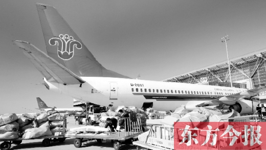 　鄭州機(jī)場的工作人員在往飛機(jī)上裝貨