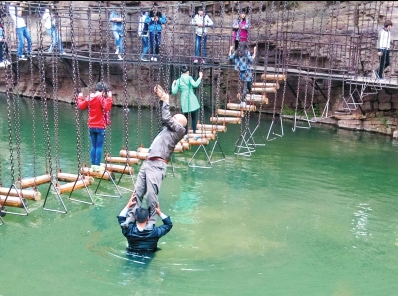 中年男游客正踩著景區(qū)安全員郭小明的肩膀過河。網(wǎng)友“@我的小名叫張孩”供圖