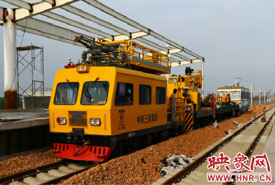 一列工程車從站臺(tái)駛過(guò)。