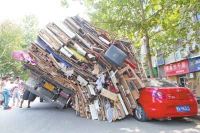 紅色小轎車(chē)被砸，卡在路邊動(dòng)彈不得。
